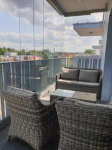 balcón con 2 sillas, mesa y sofá en Apartament North Coast - nad morzem, en Gdansk