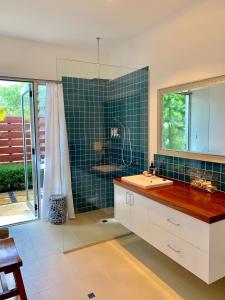 een badkamer met een wastafel, een douche en een spiegel bij Wilderness House in Margaret River Town