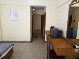una habitación con TV en un tocador y una cama en Hotel Lakeview, en Bhuj