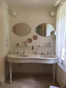 een badkamer met 2 wastafels en 2 spiegels bij Le Bocage Fleuri in Bergen