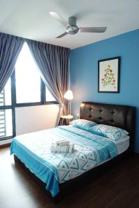 1 dormitorio azul con 1 cama y ventilador de techo en 2BR Jazz Suites Vivacity Megamall Kuching Sarawak, en Kuching