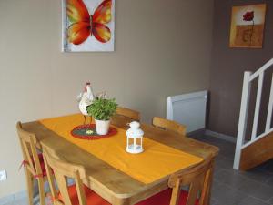 ô zirondels في La Vernelle: طاولة طعام مع طاولة وكراسي خشبية