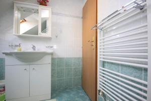 a bathroom with a sink and a shower with a mirror at Apartmán pod Černou horou in Rožnov pod Radhoštěm