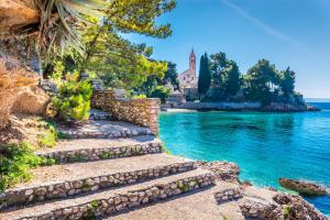 a set of stairs leading to the water with a church in the background at Tia Maria in Bol