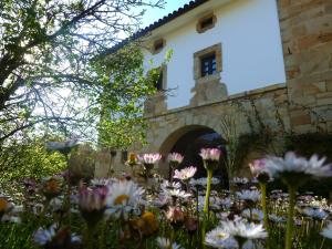 a garden of flowers in front of a building at Palacio de Arredondo in Gama