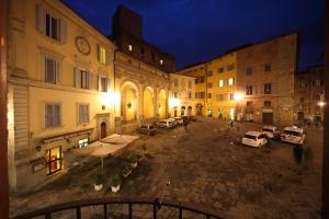 a city street at night with cars and buildings at Hotel La Perla in Siena