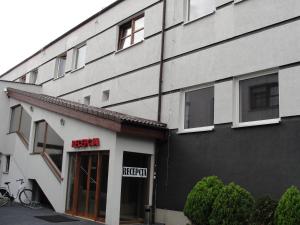 un edificio en blanco y negro con un letrero encima de la puerta en Hotel Sunny, en Poznan