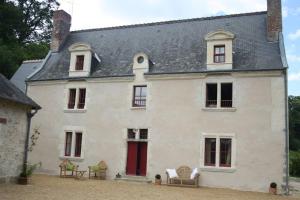 una gran casa blanca con sillas delante en Manoir - Gîte avec Spa pour 10 p., en Langeais