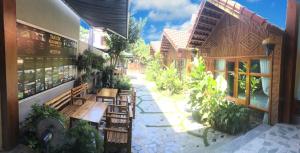 an outdoor patio with benches and tables and plants at Tam Coc Hello Homestay in Ninh Binh