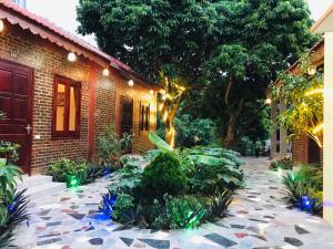 a garden in front of a brick house with lights at Tam Coc Thai Duong Homestay in Ninh Binh