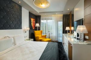 オレシャクにあるFamily Hotel Strannopriemnitzaのベッドルーム(大型ベッド1台、黄色い椅子付)