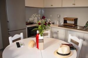a white table with a vase with flowers on it at Elysium in Glinádhon +30 photos
