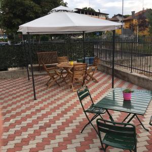 a table and chairs under an umbrella on a patio at SG Rooms - Casa Laura in Peschiera del Garda