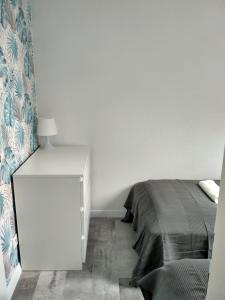 una camera bianca con letto e armadietto bianco di Apartament Kopa a Karpacz