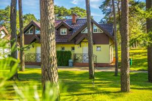Pomorze Health&Family Resort -Domki całoroczne في أوستكا: منزل في الغابة مع الأشجار