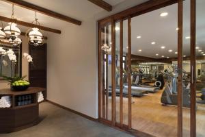 a gym with glass doors and a fitness center at Anantara Lawana Koh Samui Resort in Chaweng