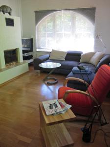 a living room with a couch and a red chair at Rossis Haus in Schneverdingen