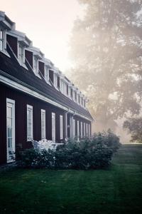 a house with a grass yard next to a building at Thoresta Herrgård in Bro +31 photos