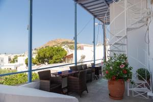 a balcony with tables and chairs and a view of a city at El Greco Studios in Patmos