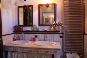 La salle de bains est pourvue de 2 lavabos et de 2 miroirs. dans l'établissement B&B Al Roncaccio, à Calco