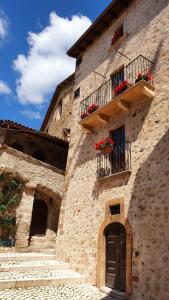 a stone building with flower boxes and a balcony at La Torretta Medicea in Santo Stefano di Sessanio