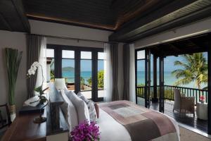 a bedroom with a bed and a view of the ocean at Anantara Lawana Koh Samui Resort in Chaweng