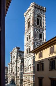 un grand bâtiment avec une tour d'horloge dans une ville dans l'établissement Hotel Costantini, à Florence