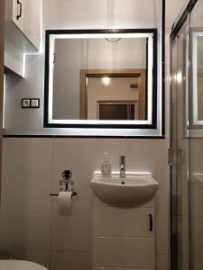 y baño con lavabo y espejo. en Kobi, en Kielce