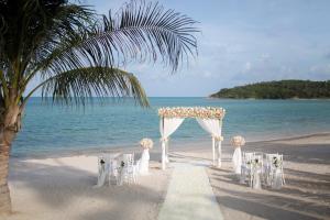 a wedding altar on the beach with a palm tree at Anantara Lawana Koh Samui Resort in Chaweng