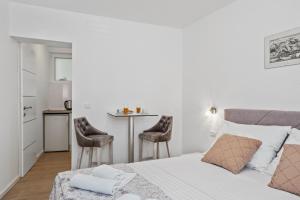 une chambre avec un lit, une table et des chaises dans l'établissement Apartmani Bruna, à Šibenik