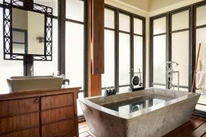 a bathroom with a large tub and a sink at Anantara Lawana Koh Samui Resort in Chaweng