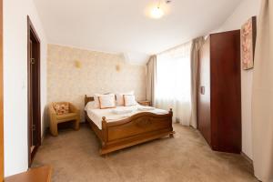 
a bedroom with a bed and a dresser at Pensiunea Casa cu Flori in Săcele
