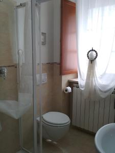 a bathroom with a toilet and a glass shower at B&B Monticelli in Gubbio