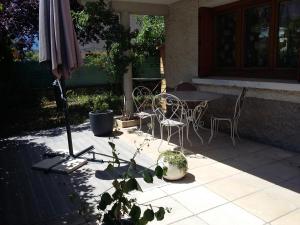 a patio with a table and chairs and an umbrella at appartement leauma in Guillestre