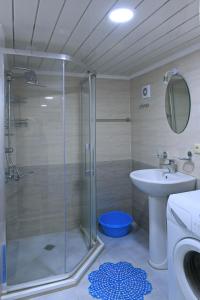 een badkamer met een glazen douche en een wastafel bij TNT apartment in Batoemi