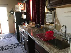 a kitchen with a sink and a black refrigerator at Nice Studio w/ AC near Kehena Beach and lava fields in Kehena