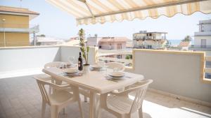 a white table and chairs on a balcony at DELPOSTO Marina di Ragusa SR in Marina di Ragusa