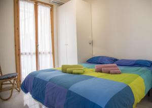 a bedroom with a colorful bed with towels on it at DELPOSTO Marina di Ragusa SR in Marina di Ragusa