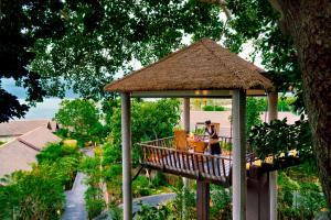 a gazebo with a woman sitting at a table at Anantara Lawana Koh Samui Resort in Chaweng