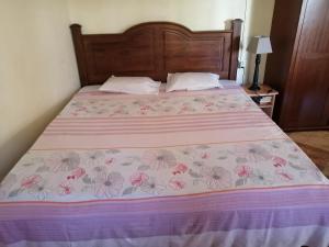 - une chambre dotée d'un lit avec un couvre-lit rose et violet dans l'établissement Mauristudio, à Bel Ombre