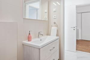 une salle de bain blanche avec un lavabo et un miroir dans l'établissement Apartmani Bruna, à Šibenik 45 autres photos