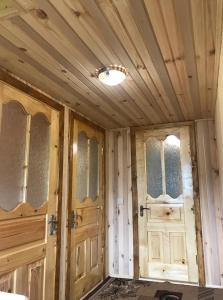 twee houten deuren in een kamer met een plafond bij Дімона in Mykulychyn