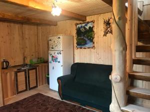 a kitchen with a refrigerator and a couch in a room at Дімона in Mykulychyn