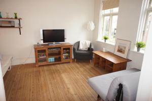 ein Wohnzimmer mit einem TV und einem Stuhl in der Unterkunft id. 061. Jyllandsgade in Esbjerg