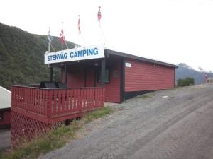 um edifício vermelho com um sinal que diz servir acampamentos em Stenvåg Camping em Eidsdal