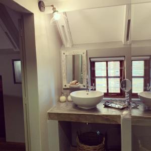 a bathroom with two sinks and a mirror at The Oystercatchers Haven at Paternoster in Paternoster