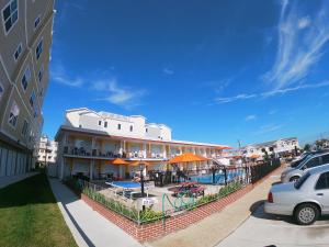 un edificio con piscina e patio con ombrelloni arancioni di Sea Chest Motel a Wildwood Crest