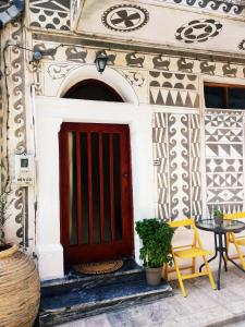 a red door on a building with a table and chairs at Xista Manor House ® in Pyrgi