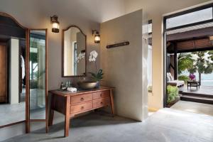 a bathroom with a sink and a mirror on a dresser at Anantara Lawana Koh Samui Resort in Chaweng