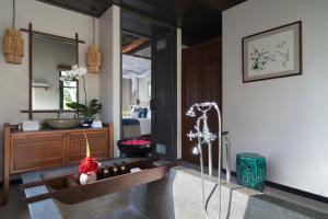 a bathroom with a bath tub with a mirror at Anantara Lawana Koh Samui Resort in Chaweng